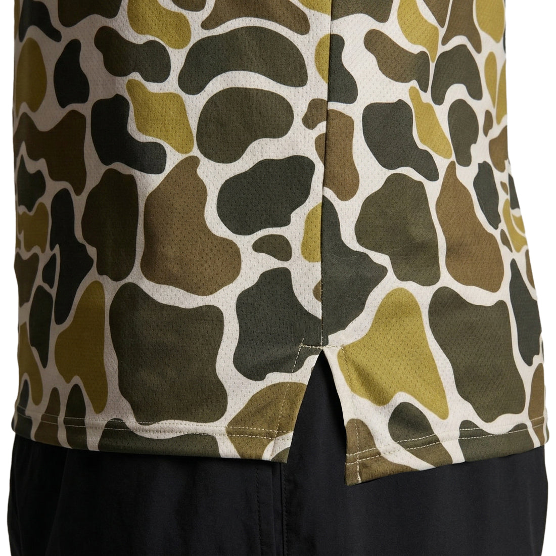 Men's Vapor Lite Racing Singlet in Urban Camo Khaki featuring a close-up view of the lower hem with side vents, showcasing an olive, brown, and cream camouflage pattern on mesh fabric, paired with black shorts.