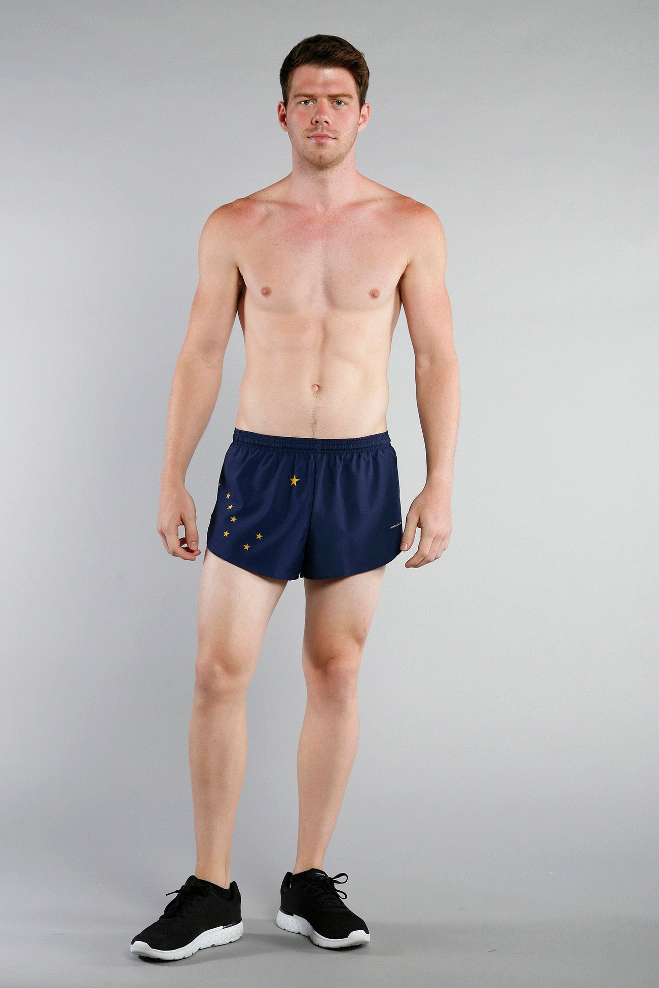 Men's Flag 1" Elite Split Shorts - Alaska, navy blue running shorts featuring gold Ursa Major constellation star pattern, modeled by a shirtless male athlete with black sneakers.