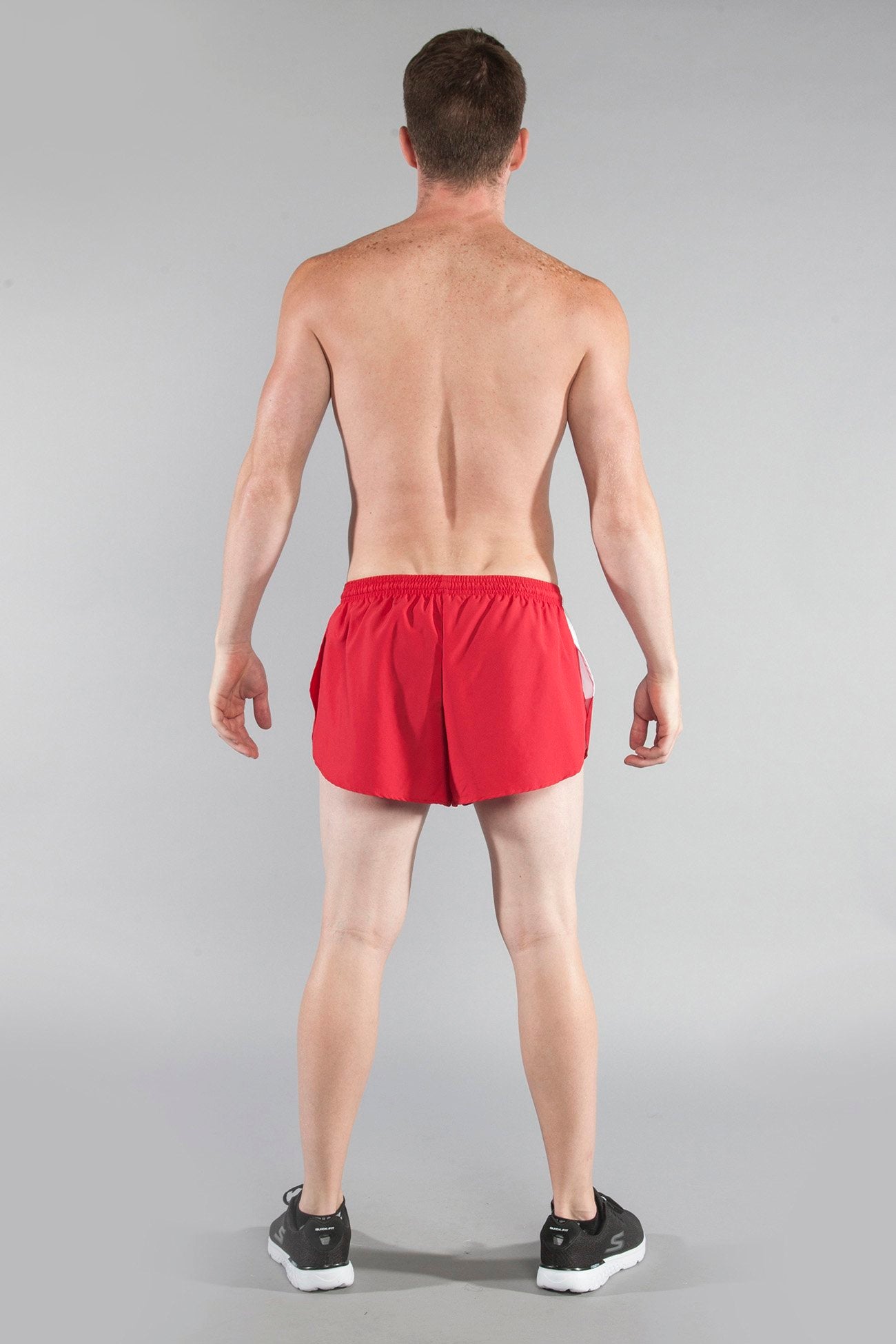 Men's Flag 1" Elite Split Shorts in red and white California colorway, shown from the back on a male model wearing black Skechers sneakers against a gray background.