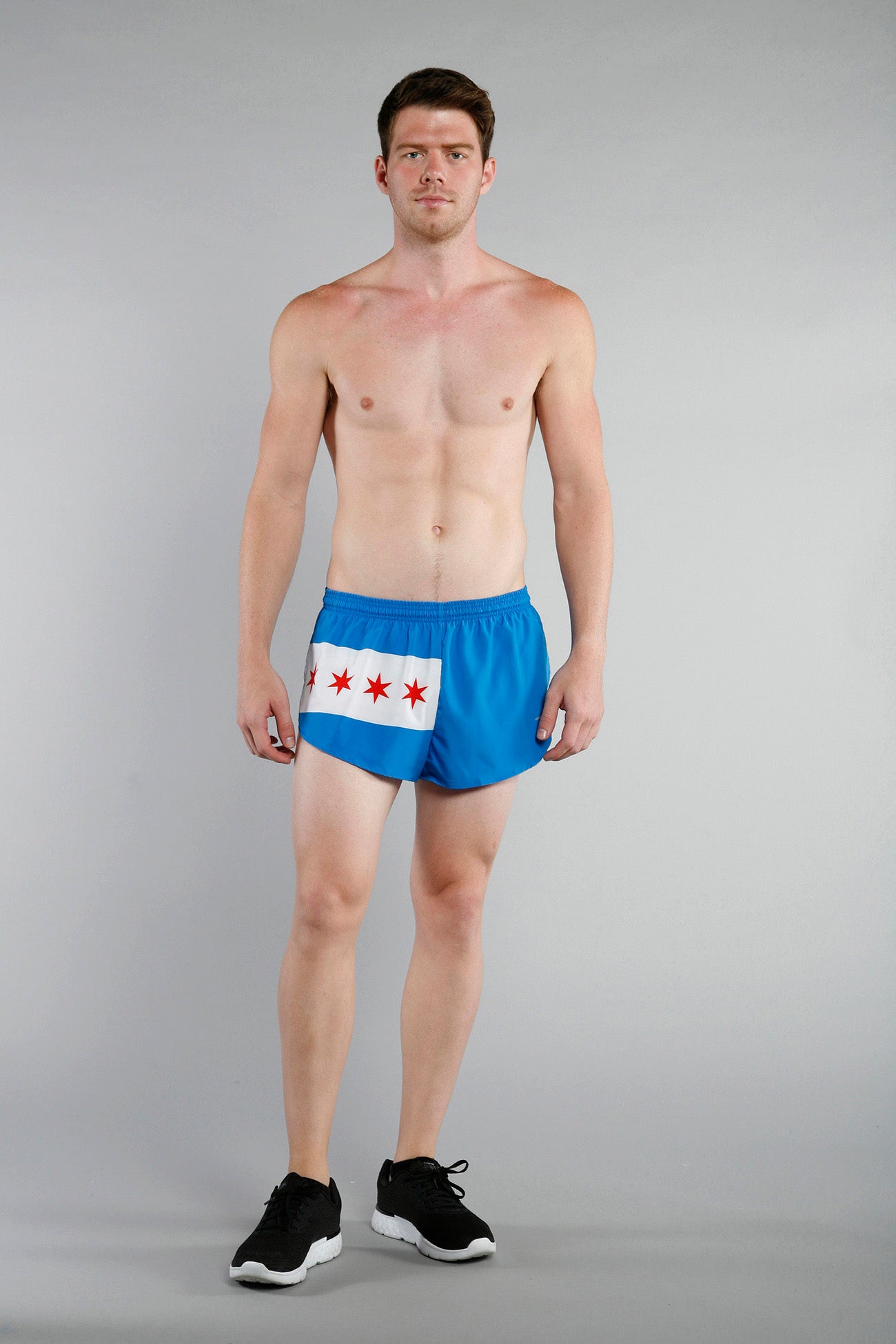 Men's Flag 1" Elite Split Shorts in Chicago flag design, featuring blue fabric with a white stripe and four red six-pointed stars, worn by a male model with black sneakers against a gray background.