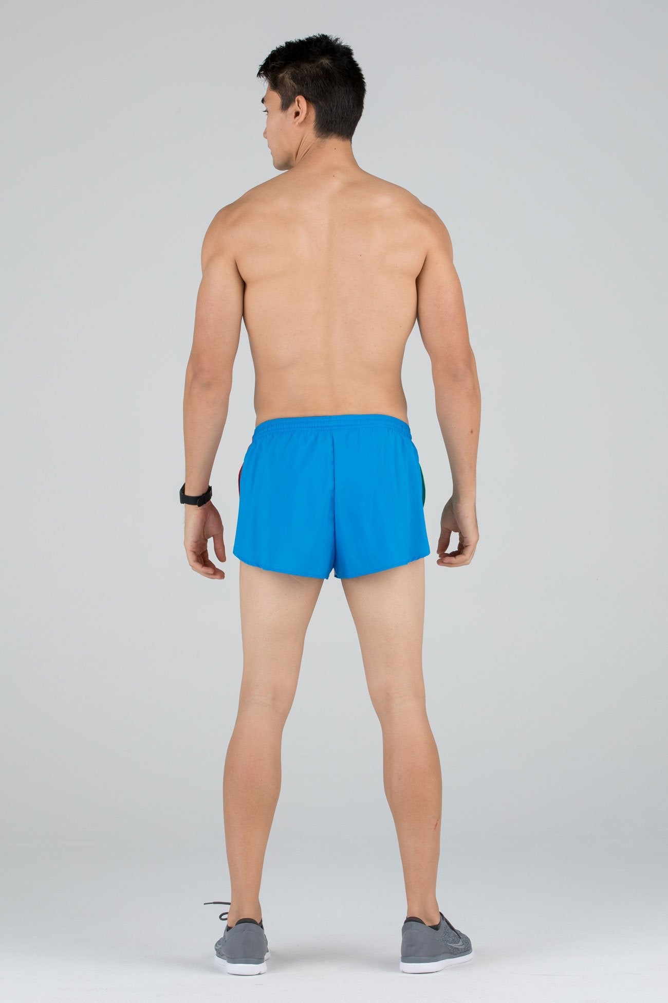 Men's Flag 1" Elite Split Shorts in bright blue with Ireland flag side panel detail, shown from the back on a shirtless male model wearing gray sneakers.