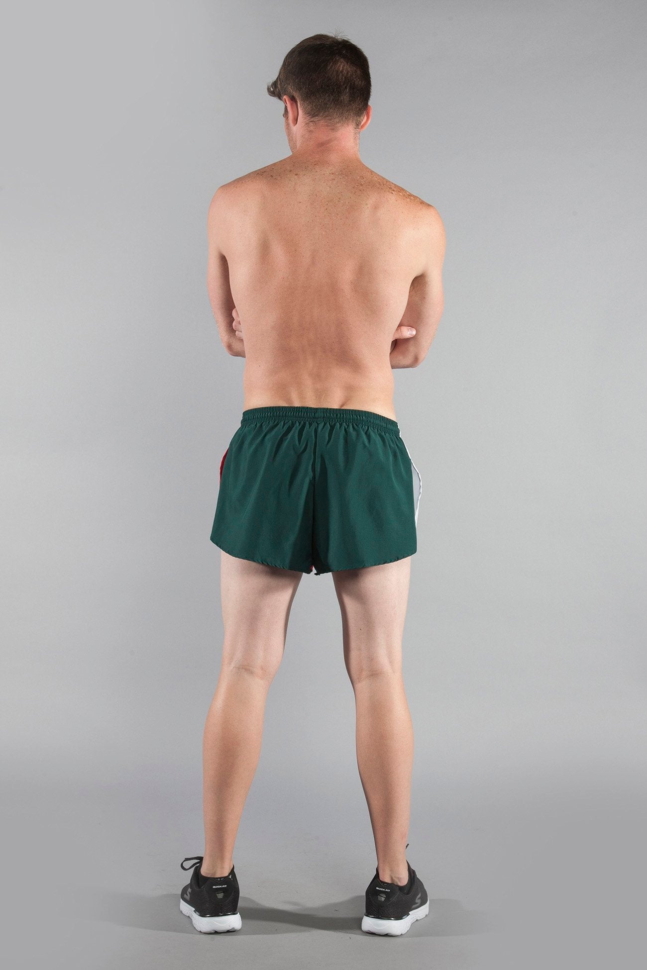 Men's Flag 1" Elite Split Shorts in Mexico colorway, shown from the back on a male model, featuring dark green fabric with red and white side stripe detailing and an elastic waistband, paired with black sneakers.