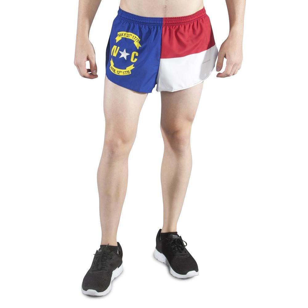 Men's Flag 1" Elite Split Shorts featuring the North Carolina state flag design with blue, red, and white panels and the NC seal on the left leg, worn by a male model with black sneakers.