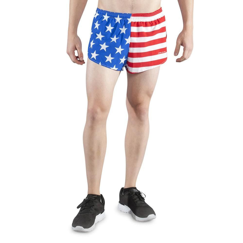 Men's Flag 1" Elite Split Shorts in American Flag design featuring a blue field with white stars on the left panel and red and white stripes on the right panel, worn by a male model with black sneakers against a white background.