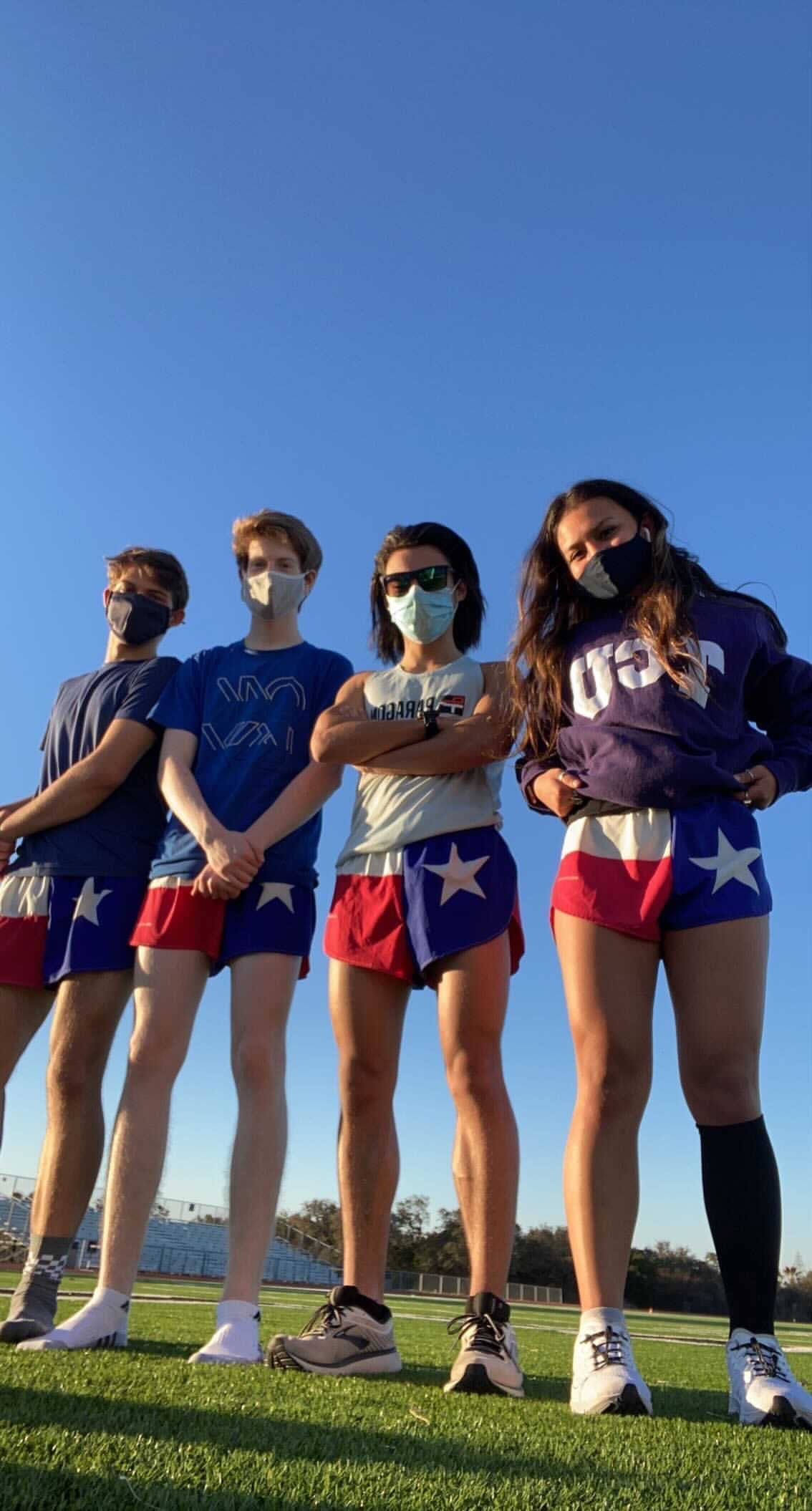 Men's Flag 1 Elite Split Shorts in Texas flag design featuring red, white, and blue panels with a lone star, worn by a group of four young athletes on a track field.